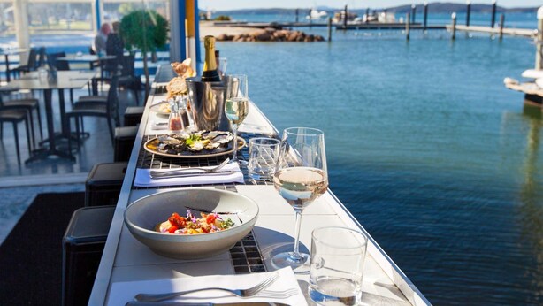 Una mesa de comedor con mariscos, copas de vino y una botella de champán.