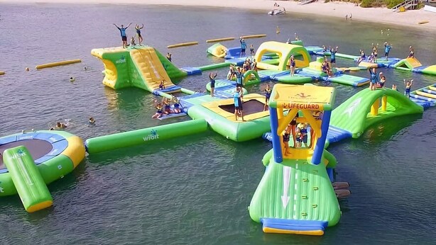 An inflatable water park with various play structures and slides. - Sea La Vie One - Salt Air & Sunsets (Salamander Bay)