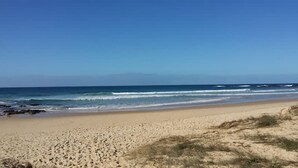 A beach with a sandy shore and waves. - Kilaben Bay Escape - Minutes to the Water (Kilaben Bay)