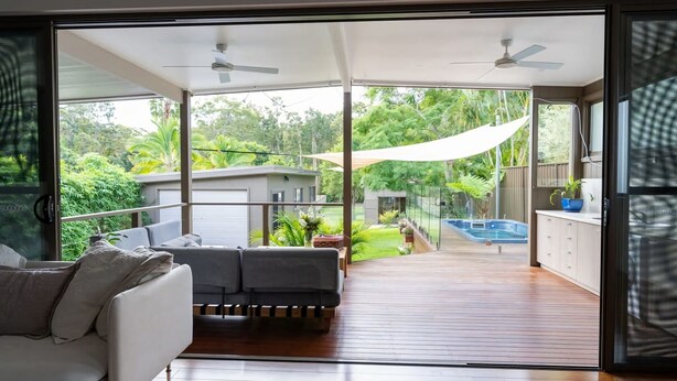 A modern interior with a balcony, a pool, and a view of a lush garden. - Kilaben Bay Escape - Minutes to the Water (Kilaben Bay)