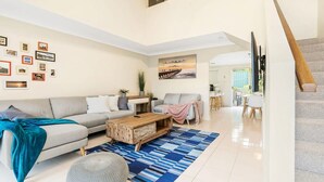 A modern living room with a sofa, coffee table, and a painting on the wall.