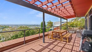 A wooden deck with a pergola, outdoor furniture, and a grill area. - Hilltop Hideaway Merewether Family Escape (Merewether)