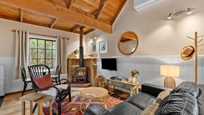 A cozy living room with a fireplace, comfortable seating, and a television. - Romantic Tricklebeck Spa Cottage (Blackheath)