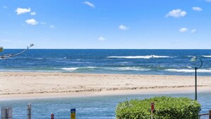 Ein Strand mit freiem Blick auf den Ozean, einem Sandufer und einer Straßenlaterne.
