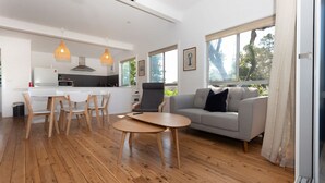 A modern living space with a dining area, kitchen, and seating area. - Beachfront Bliss Broulee (Broulee)