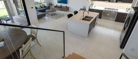 Un espacio habitable moderno y abierto con cocina, comedor y balcón.