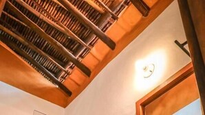 A bathroom with a glass shower enclosure, a wooden ceiling, and a mirror with a wooden frame. - Hotel Tierra Roja  (Barichara)