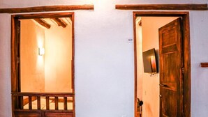 A hallway with a wooden door marked "101" and a window with a wooden frame. - Hotel Tierra Roja  (Barichara)