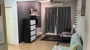 A room with a bed, a desk, a chair, a wardrobe, and a ceiling fan. - Homestay WaDi 2, Apartment with pool near beach (Port Dickson Town)