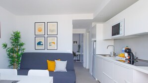 A modern apartment with a living area, kitchen, and dining space.