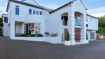 Stunning two-story house with a spacious front yard and a paved driveway leading to the entrance.