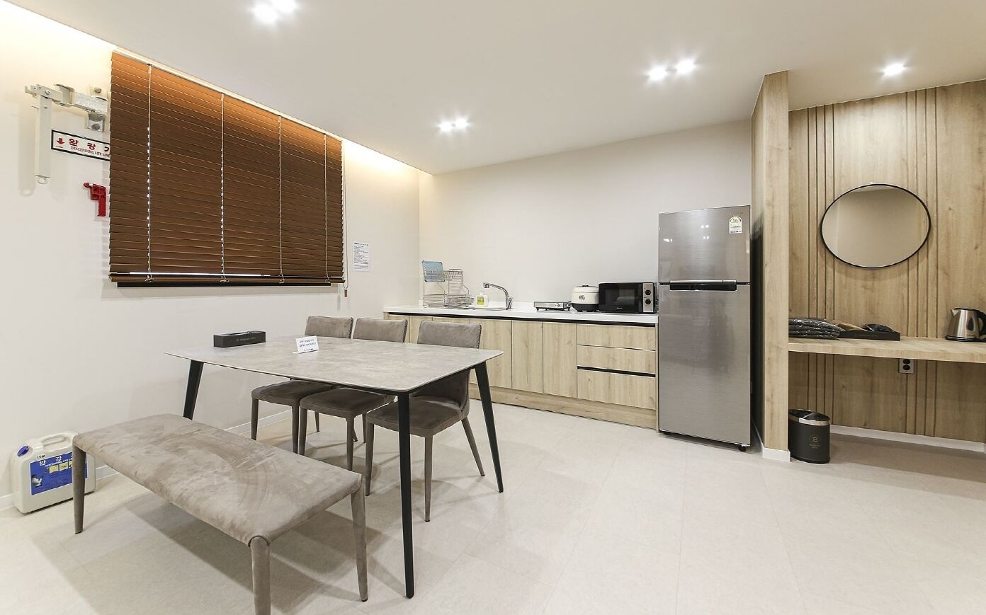 A modern kitchen with a dining area, including a table, chairs, and a bench.
