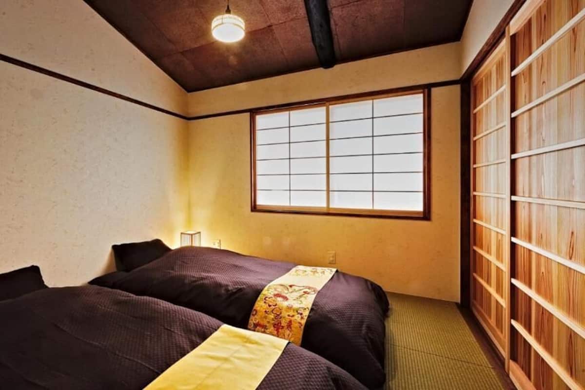 Een traditionele Japanse kamer met tatami vloeren, een shoji scherm en een futonbed.