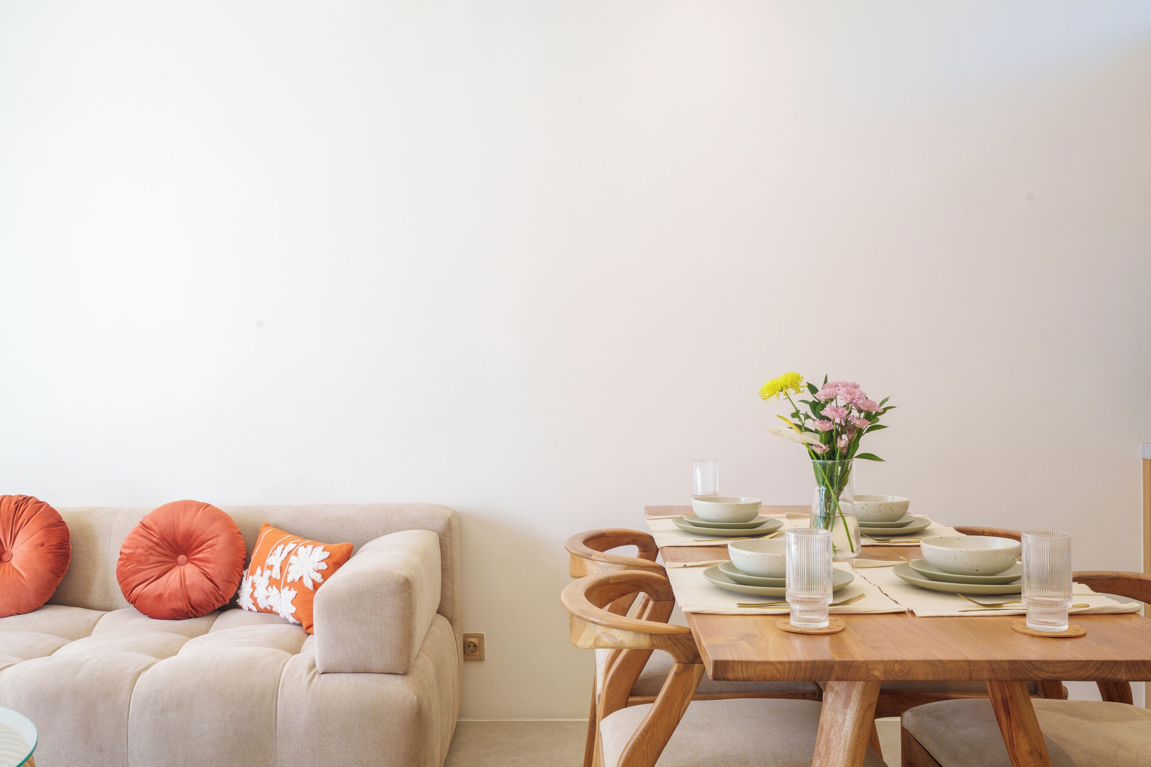 Een eetruimte met een houten tafel gedekt voor vier personen, omringd door comfortabele stoelen.