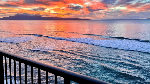 Une vue sur la côte, avec des vagues et un coucher de soleil.