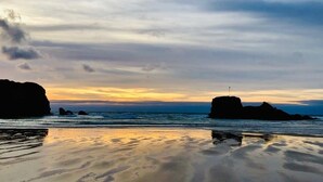 A beach with calm waters and distant rock formations under a cloudy sky. - 2Br Lodge - Pool - Fireplace - PetsOK - Parking (Newquay)