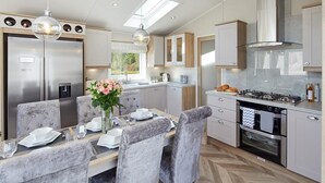 A modern kitchen with a built-in oven, a gas stove, and a stainless steel refrigerator. - 2Br Lodge - Pool - Fireplace - PetsOK - Parking (Newquay)