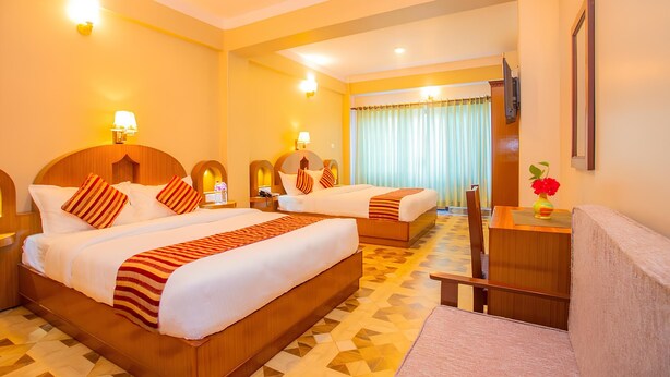 A hotel room with two beds, a desk, and a chair. - Hotel Liberty (Pokhara)