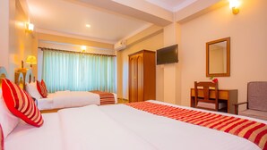 A hotel room with two beds, a desk, a chair, a TV, and a wardrobe. - Hotel Liberty (Pokhara)
