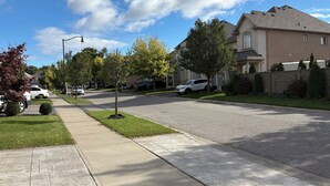 A residential street with houses, parked cars, and a sidewalk. - Beautiful Priv. bsmt 2B 1Bath apartment w/ parking (Brampton)