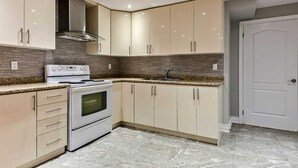 A modern kitchen with a built-in oven, stainless steel range hood, and light-colored cabinets. - Beautiful Priv. bsmt 2B 1Bath apartment w/ parking (Brampton)
