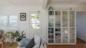 Un salon avec un canapé, une bibliothèque et une porte donnant sur un balcon.