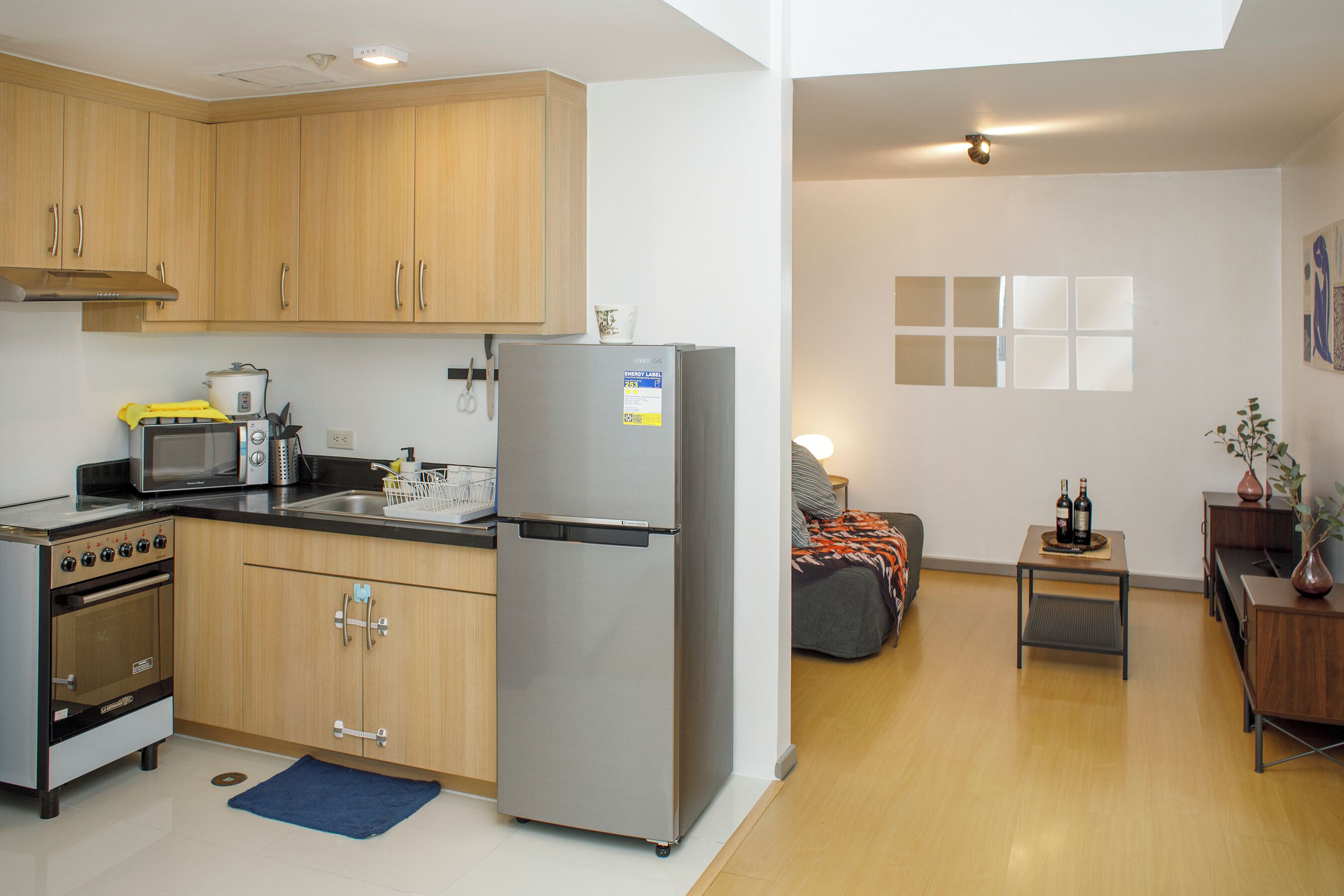 A compact kitchen with modern appliances, wooden cabinets, and a small dining area with a table and chairs.