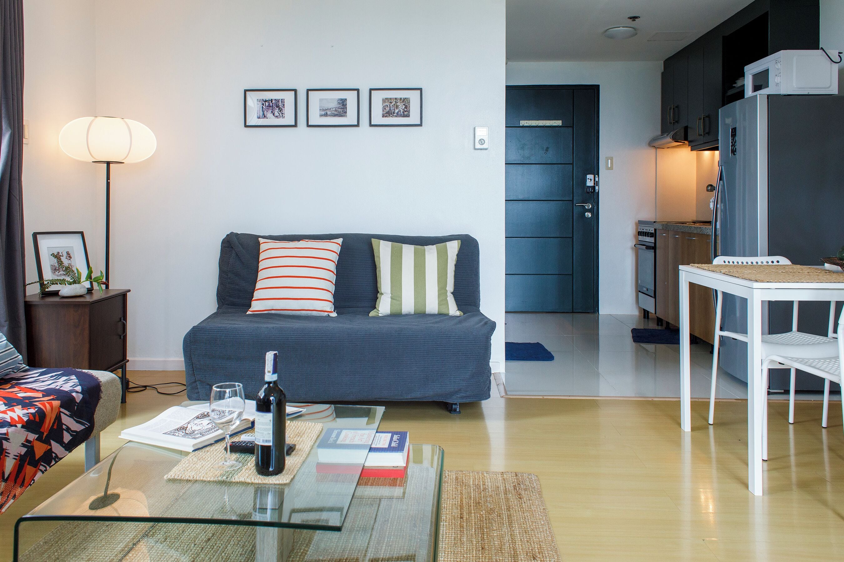 A modern living room with a sofa, coffee table, and a dining area with a table and chairs.