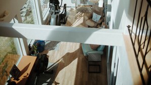 Un loft spacieux à plusieurs niveaux, doté de grandes fenêtres et offrant une vue sur l’extérieur.