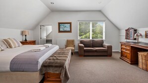 Un dormitorio con cama, una silla, un escritorio y un ventanal.