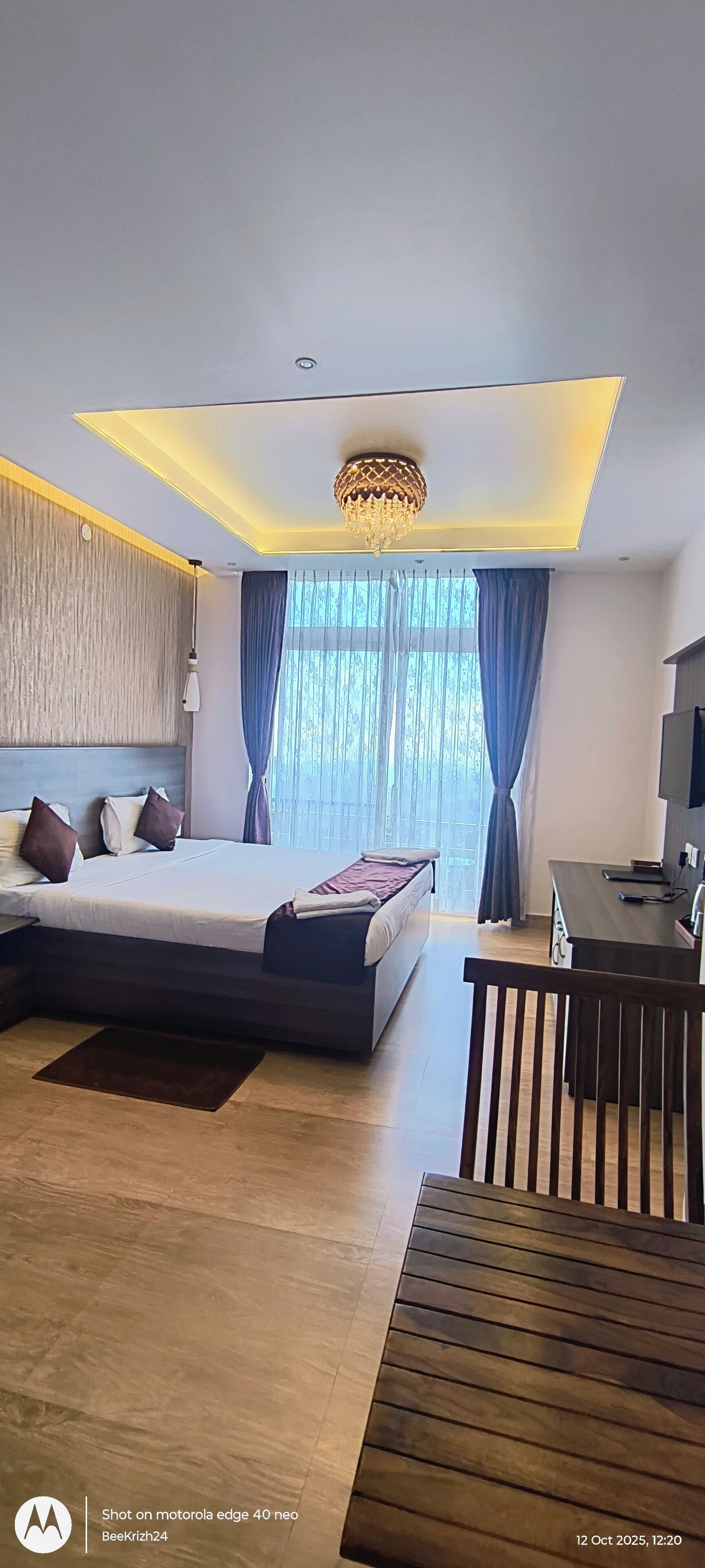 Een moderne hotelkamer met een groot bed, een bureau en een televisie.