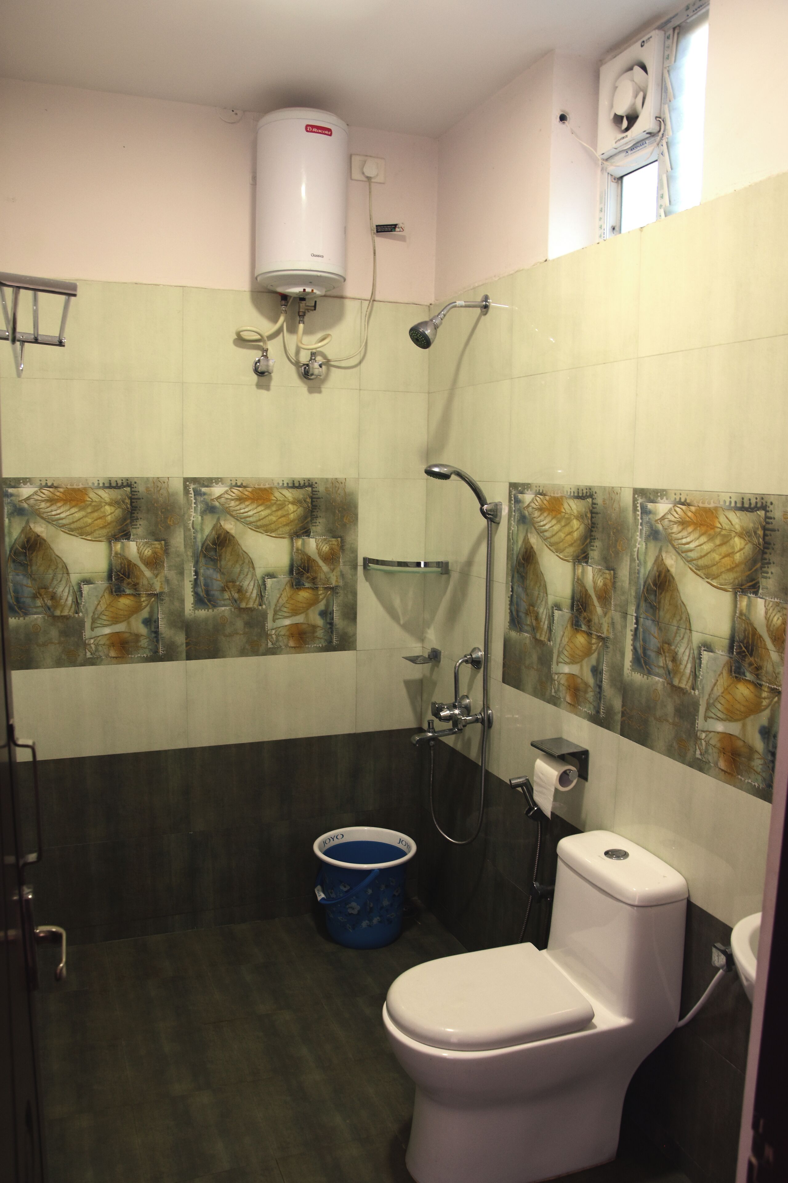 A bathroom with a toilet, a shower, and a water heater.