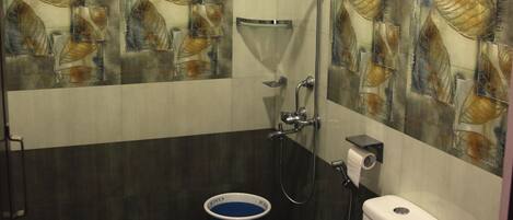 A bathroom with a toilet, a shower, and a water heater.