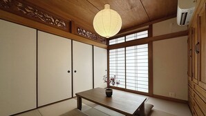 A traditional Japanese room with tatami flooring, a low table, and sliding doors. - Eight Valley Nakamachi (Hiroshima)