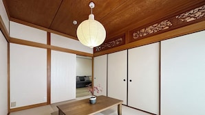 A traditional Japanese room with tatami flooring, a low wooden table, and sliding shoji doors. - Eight Valley Nakamachi (Hiroshima)