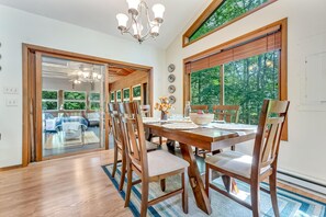 Un coin repas avec une table en bois, des chaises et un lustre.