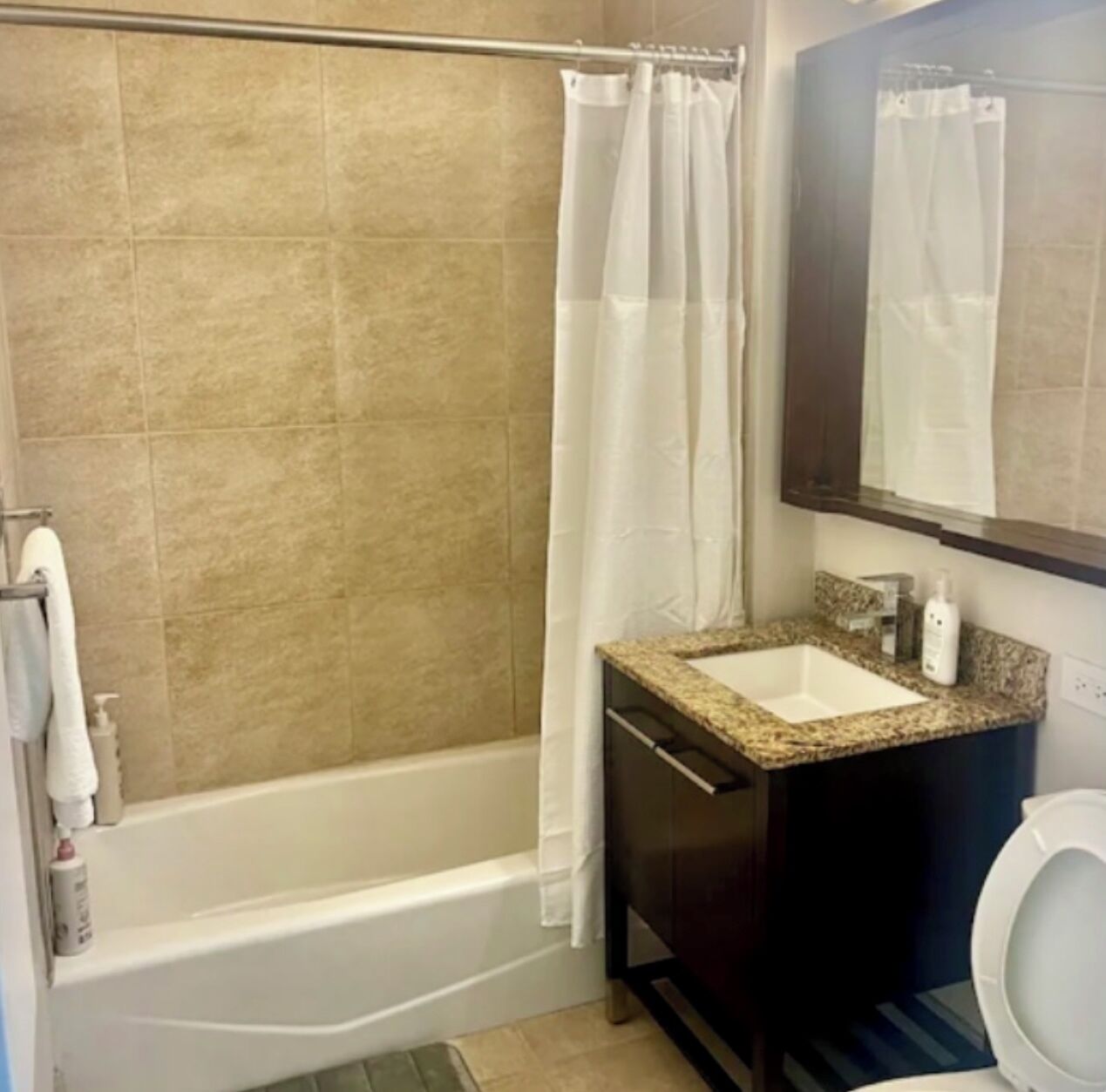 Une salle de bain avec une baignoire, un lavabo, des toilettes et un miroir.