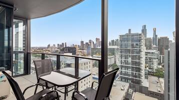 Relax on the balcony with a panoramic view of the city skyline, enjoying the view from the comfort of a small table and four chairs.