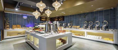 A modern interior with a central counter displaying various items, shelves with kitchenware, and decorative lighting.