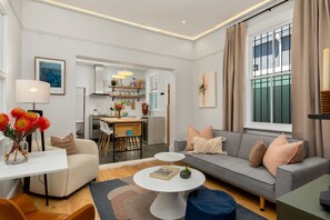 Een moderne woonkamer met een bank, salontafel en eethoek.