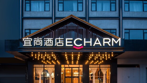 A hotel entrance with a sign reading "ECHARM" and a modern architectural design. - Yishang Hotel (Zhanjiang)