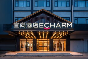 A hotel entrance with a sign reading "ECHARM" and a modern architectural design. - Yishang Hotel (Zhanjiang)