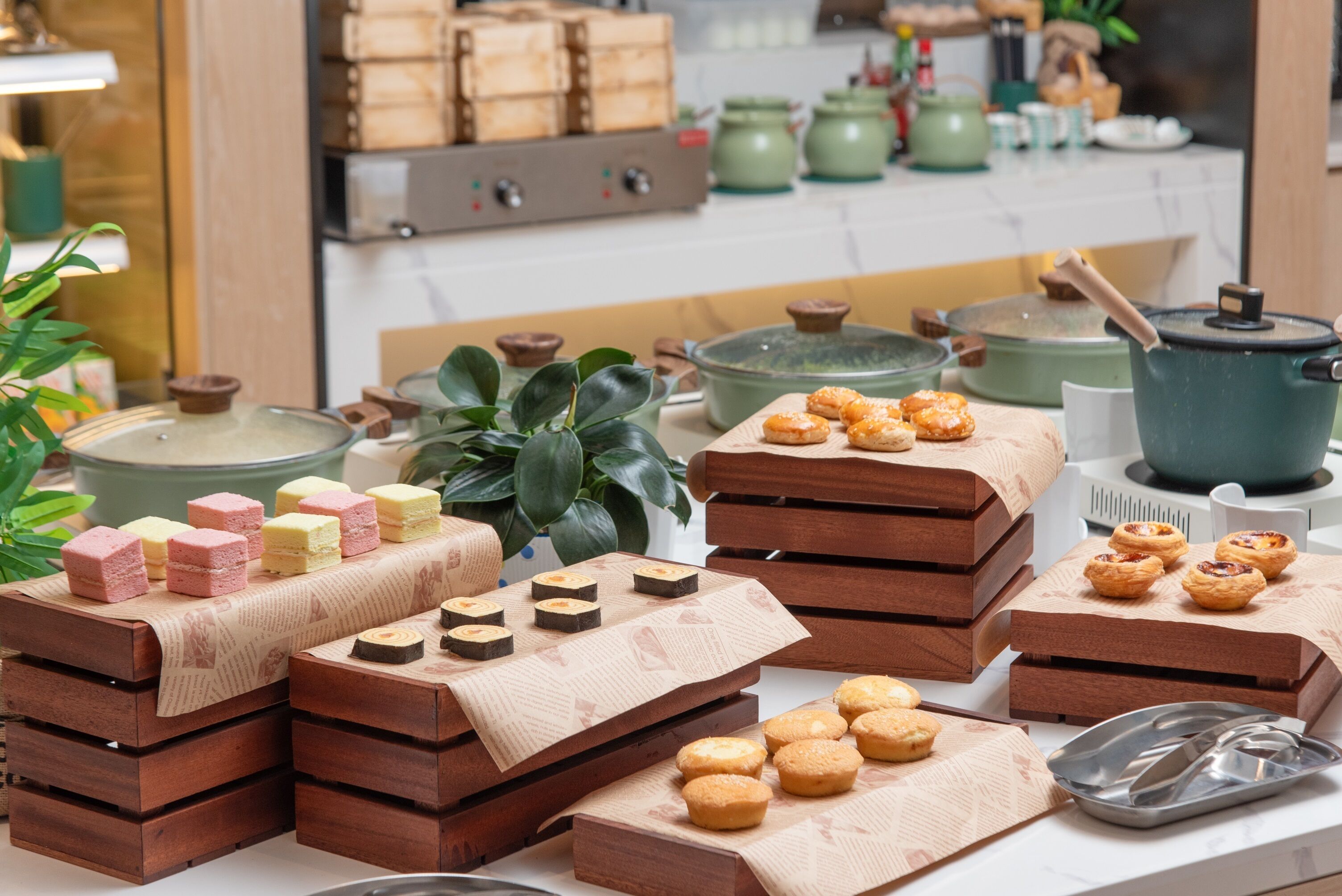 Una cocina con cajas de madera apiladas con pasteles y una olla verde sobre la encimera.