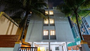 A modern building with a central entrance, multiple windows, and palm trees. - Itsy Hotels Iconic (Pune)