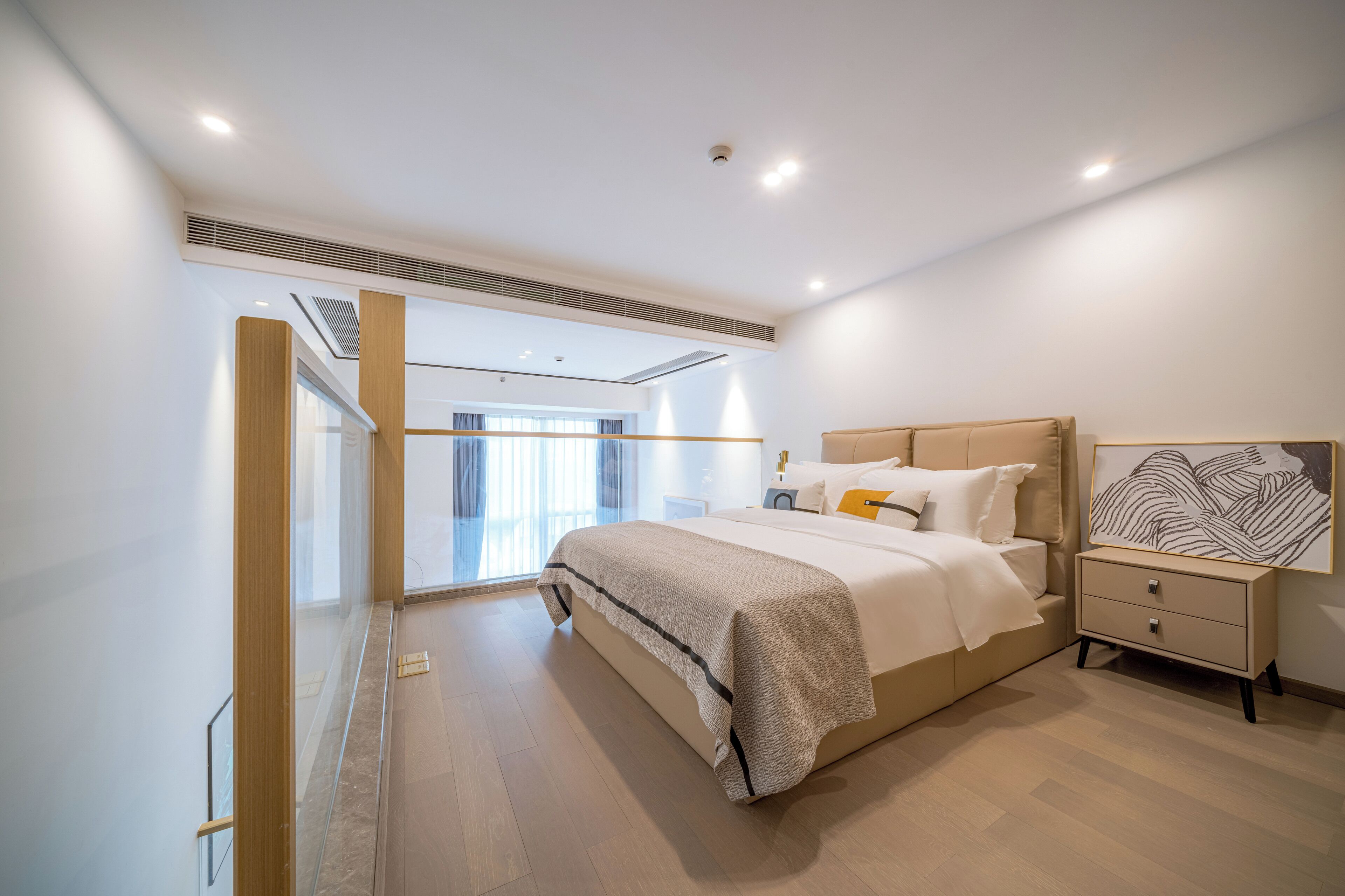 Un dormitorio moderno con una cama grande, mesitas de noche y vistas al exterior.