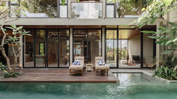 A modern house with a pool, two lounge chairs, and a dining area with a table and chairs. - The Akasha Canggu Luxury Villas (Canggu)
