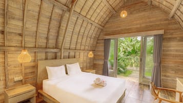Een ruime slaapkamer met een groot bed, houten plafond en uitzicht op groen.