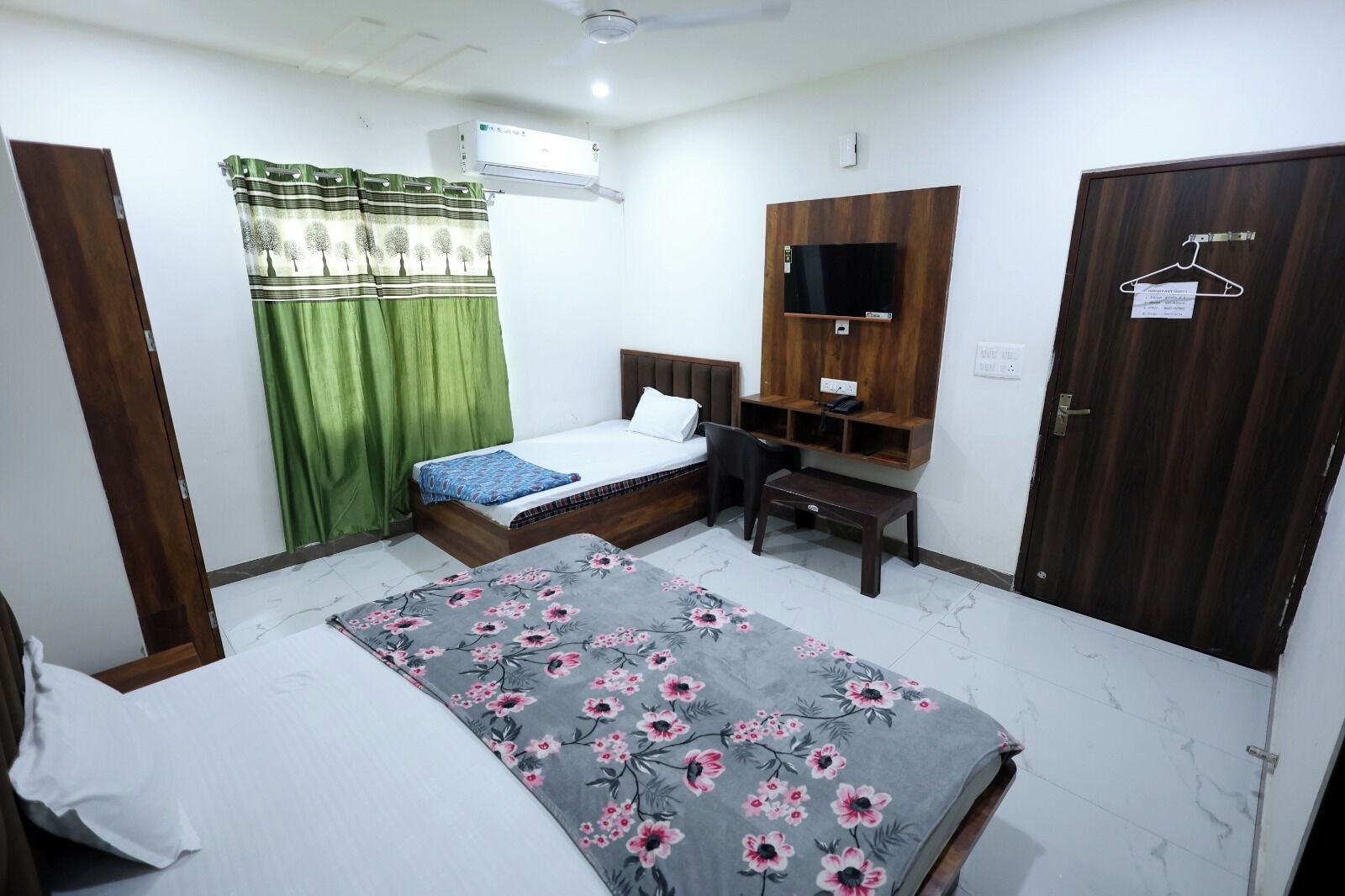 Une chambre à coucher comprenant un lit, un bureau, une armoire et un appareil de climatisation.