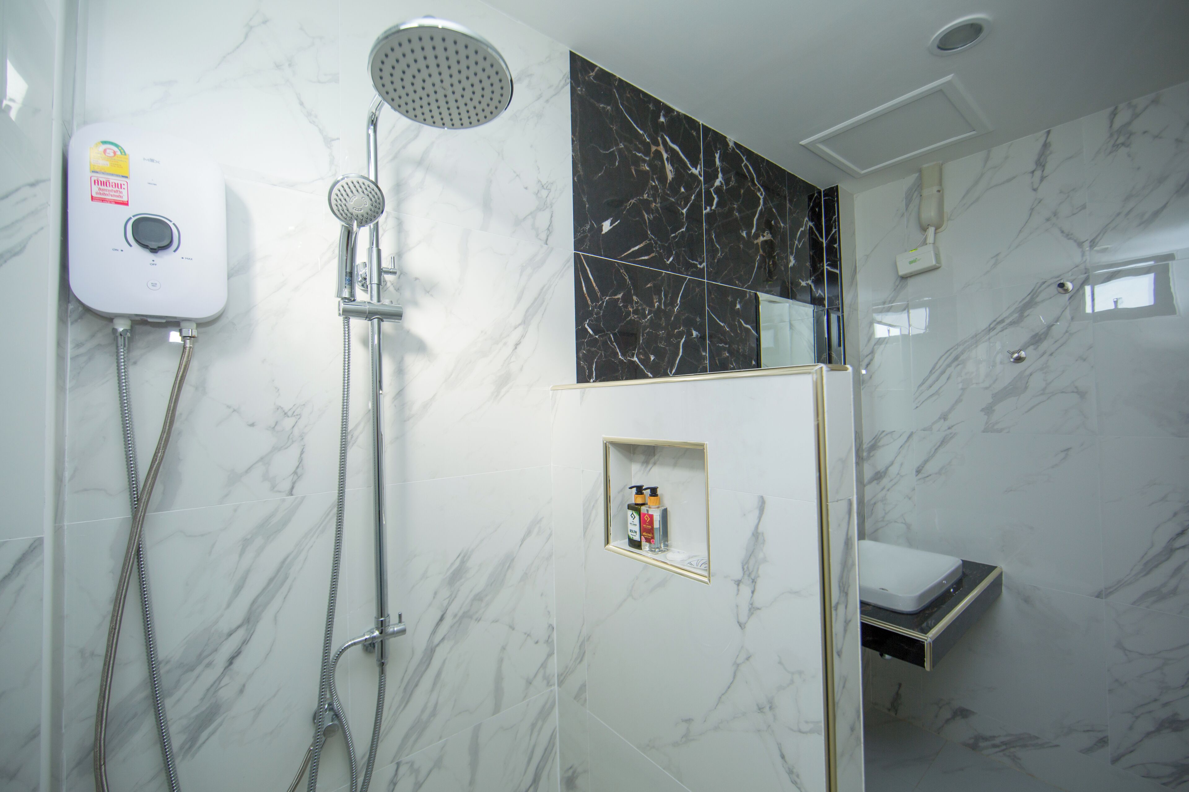 A bathroom with a shower, a toilet, and a sink.