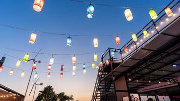 A building with a metal staircase and a string of colorful hanging lights.